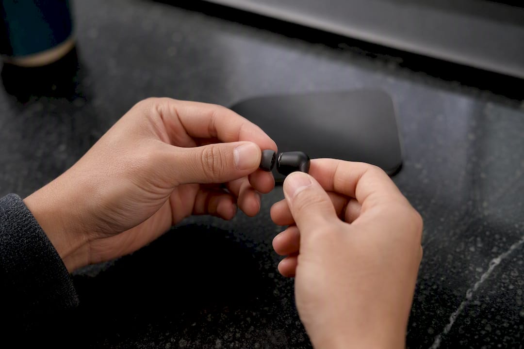 Hands gently removing silicone earbud tip
